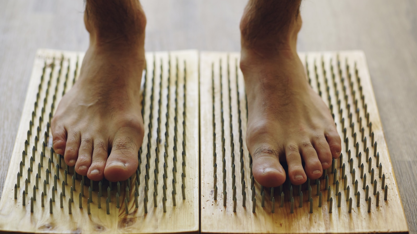 Feet standing on wooden boards with nails